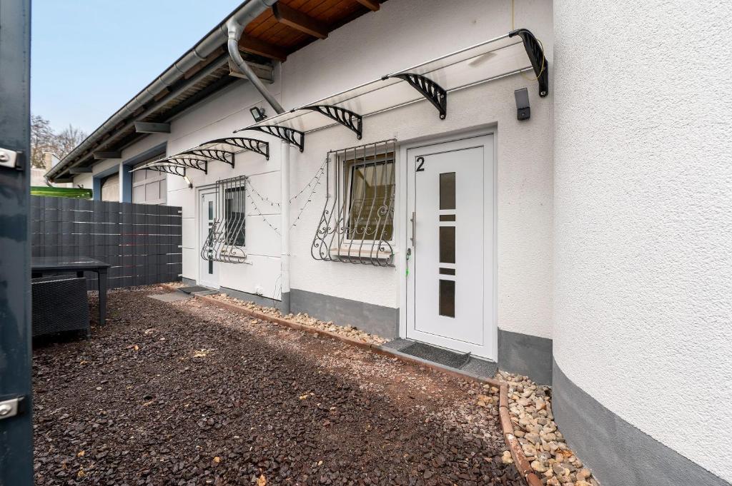 a white building with a door on the side of it at Cozy 2-bed Room With Kitchen W2 in Beckingen