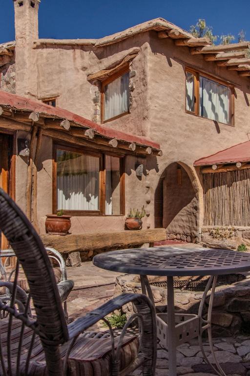 a table and chairs in front of a house at Refugio Del Pintor in Tilcara
