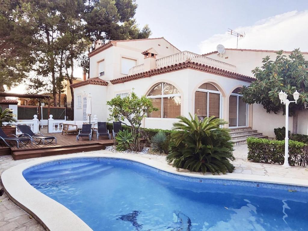 a house with a swimming pool in front of a house at Villa Xaloc piscine privée in Les tres Cales