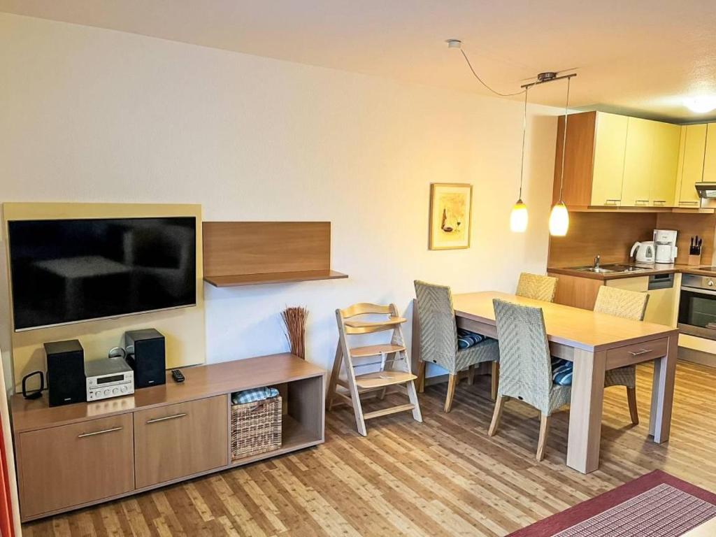 a kitchen and a dining room with a table and chairs at Ferienhaus Seepark 104 in Hoddersdeich