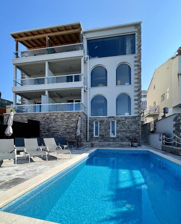 a building with a swimming pool in front of a building at Apartment LaVilla in Mlini