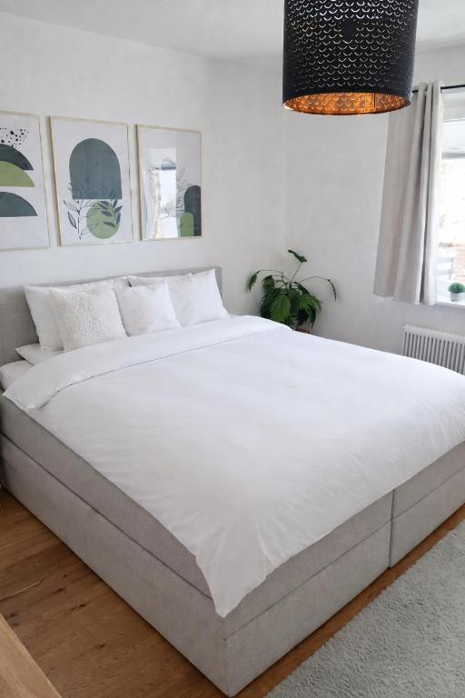 a large white bed in a white bedroom at Das Litzldorf in Sankt Michael im Lungau