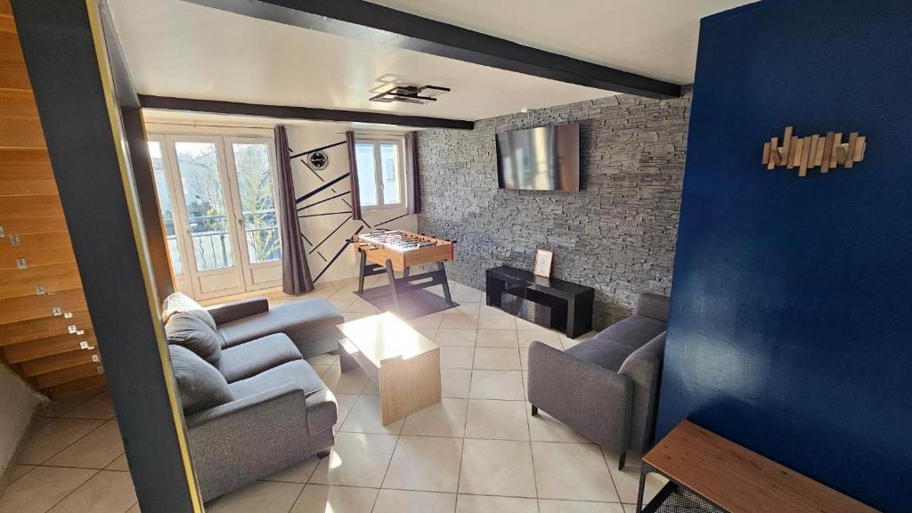 a living room with two couches and a table at Blue Duplex Proche Paris & Stade De France in Drancy
