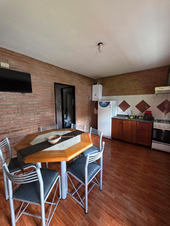 a dining room with a table and chairs and a kitchen at Complejo de departamentos 7 Cielos in Villa Carlos Paz