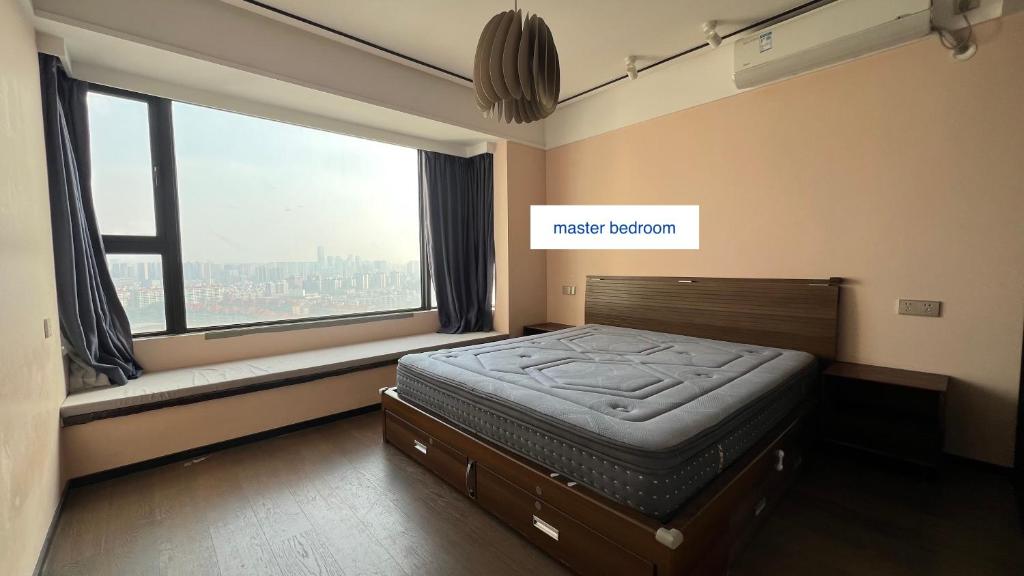 a bedroom with a bed and a large window at Family-friendly apartment in Dongguan