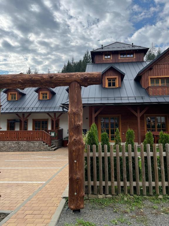a large house with a fence in front of it at Apartmán La Šiška - Věžička in Velké Karlovice