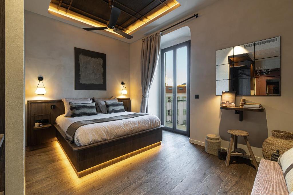 a bedroom with a bed and a balcony at WABI-SABI Hôtel Lorrain - Self Check-in in Nice