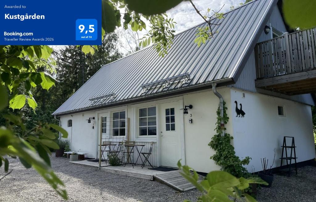 a white cottage with a metal roof at Kustgården in Abbekås