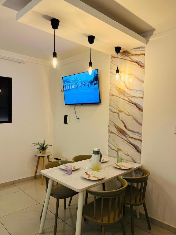 a dining room with a table and a tv on a wall at Pôr do Sol - Serraruna in Araruna