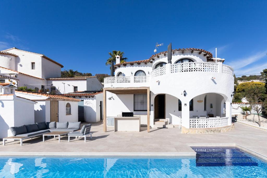 a villa with a swimming pool in front of a house at Casa SD in Casas de Torrat