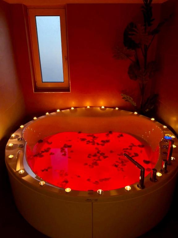a red bath tub with lights in a bathroom at VISAJ Jacuzzi Romantic in Timişoara