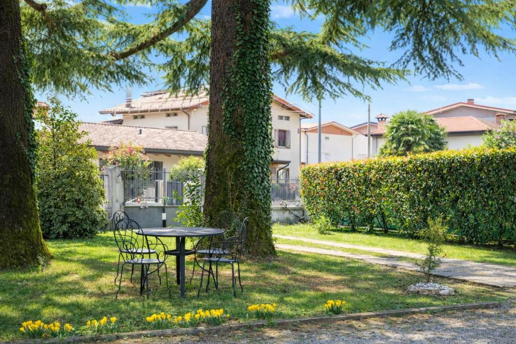 a table and chairs in a yard with trees at Cjase mê in Tarcento