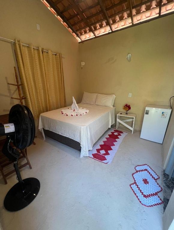 a bedroom with a bed in a room with a camera at Bougainvillea Atins in Atins