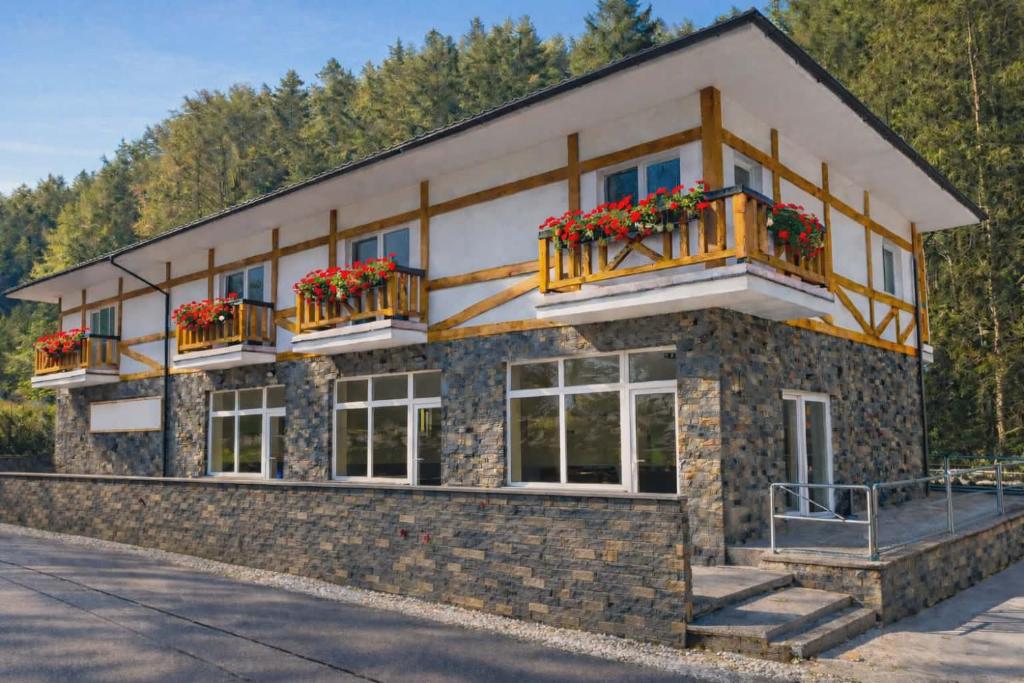 a building with balconies and flowers on it at Hangot Apartments in Repisko