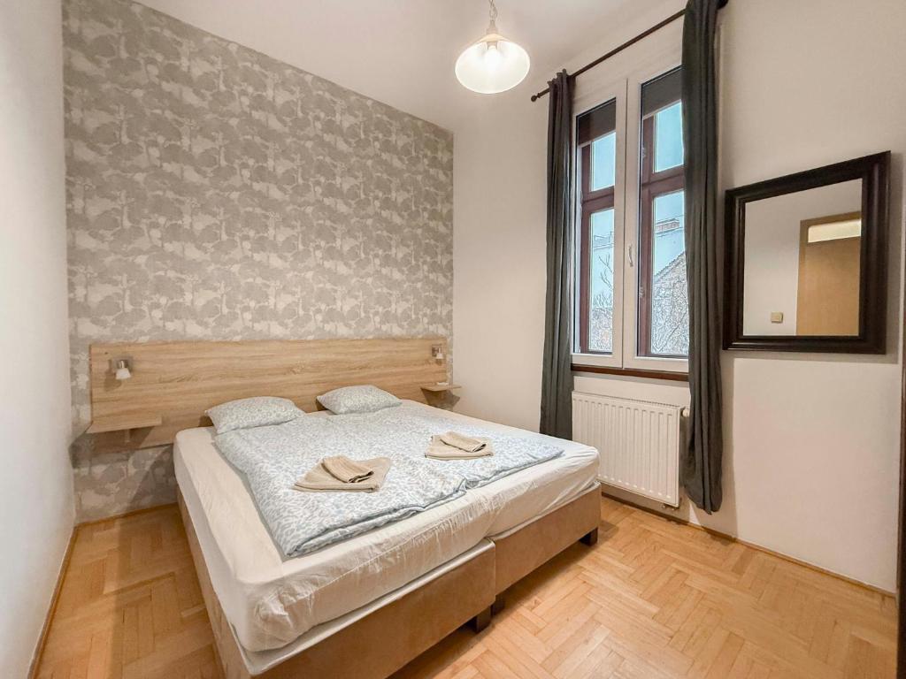 a bedroom with a bed with two slippers on it at K13 Gozsdu Apartment in Budapest