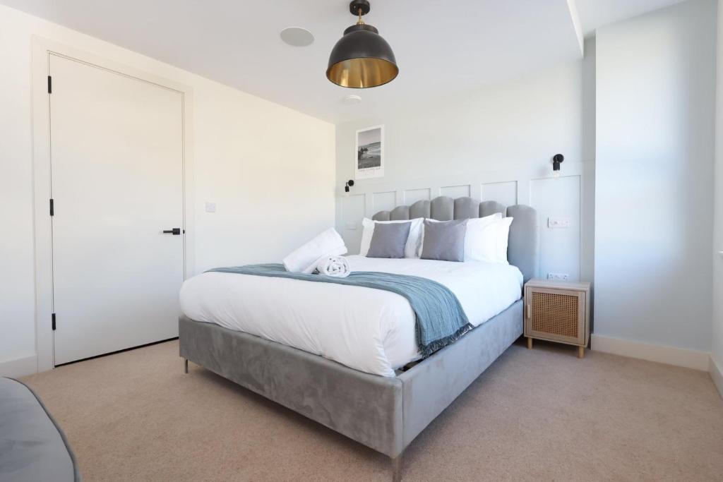 a bedroom with a large white bed with white pillows at Albert Hall 1 Bed ApartHotel- Food & Bar Onsite in Swansea
