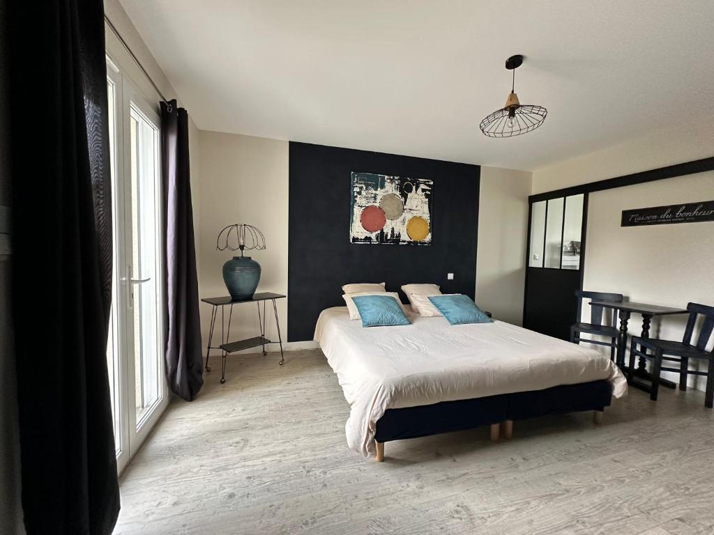 a bedroom with a large bed with blue pillows at L Ecrin d Anabelle in Saint-Georges-lès-Baillargeaux