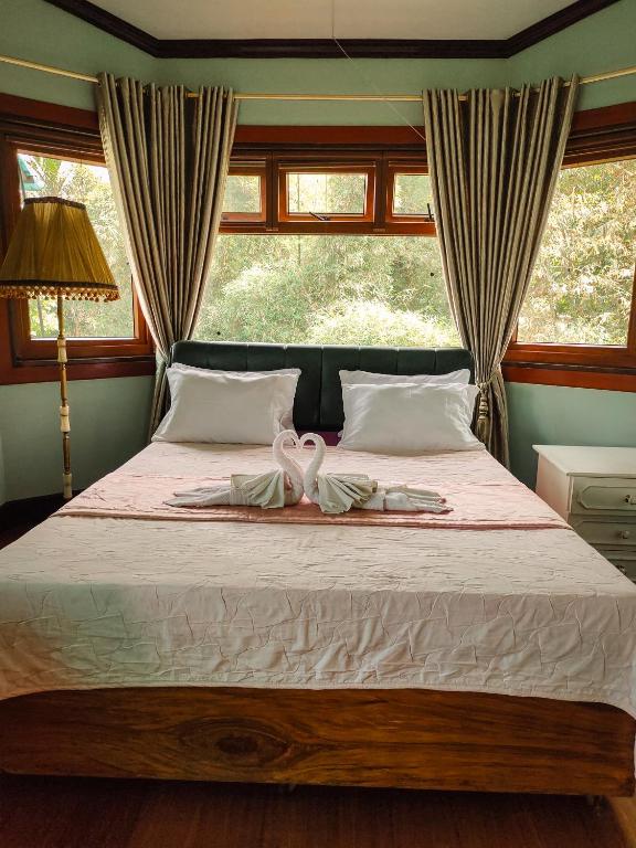 a bedroom with a bed with two towels on it at White House Benguet in Sablan