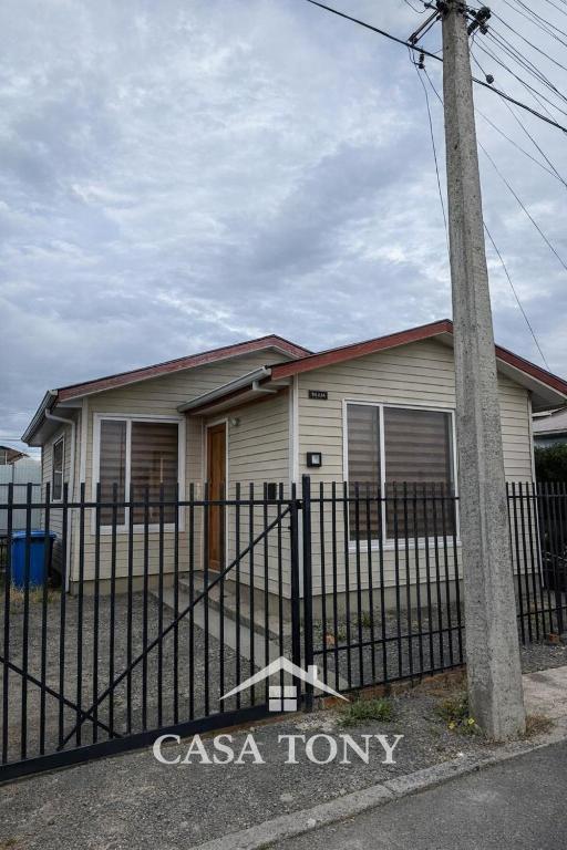 a house with a fence in front of it at Casa Tony Natales in Puerto Natales