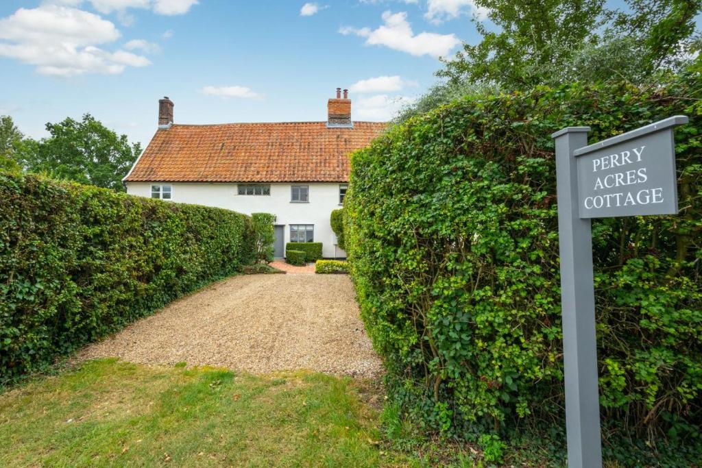 a sign in front of a house with a hedge at 2 Bed in Saxtead oc-pera in Saxtead