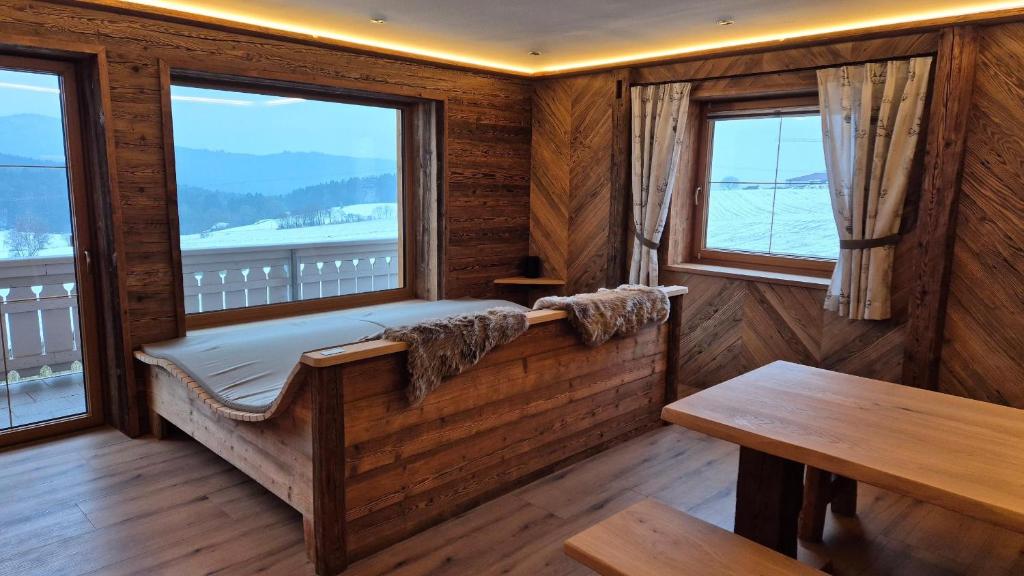 a room with a bench and two windows at Chalet Auszeit - Wohlfühlzeit Naturdesign Chalet`s in Rimbach