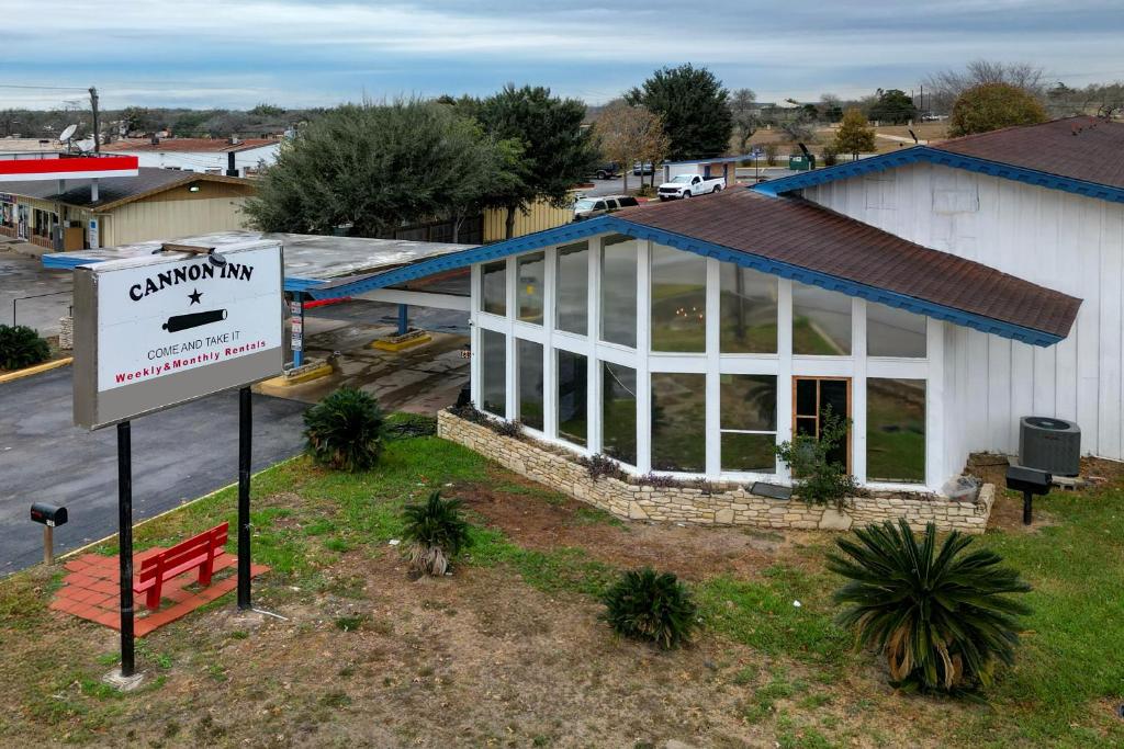 a building with a sign in front of it at Cannon Inn By Capital O Gonzales Tx in Gonzales