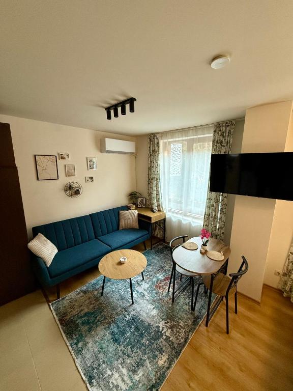 a living room with a blue couch and a table at Panorama Studio Home2Host in Bansko