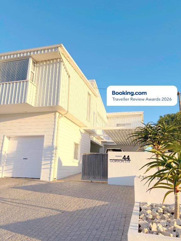 a white house with a driveway in front of it at Beachouse@Stilbaai in Stilbaai