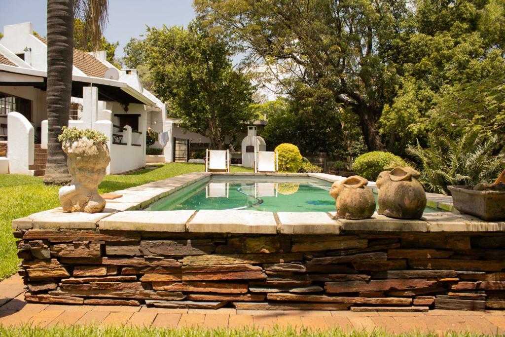 ein Pool mit zwei Tierstatuen daneben in der Unterkunft De Witte Loft in Newcastle