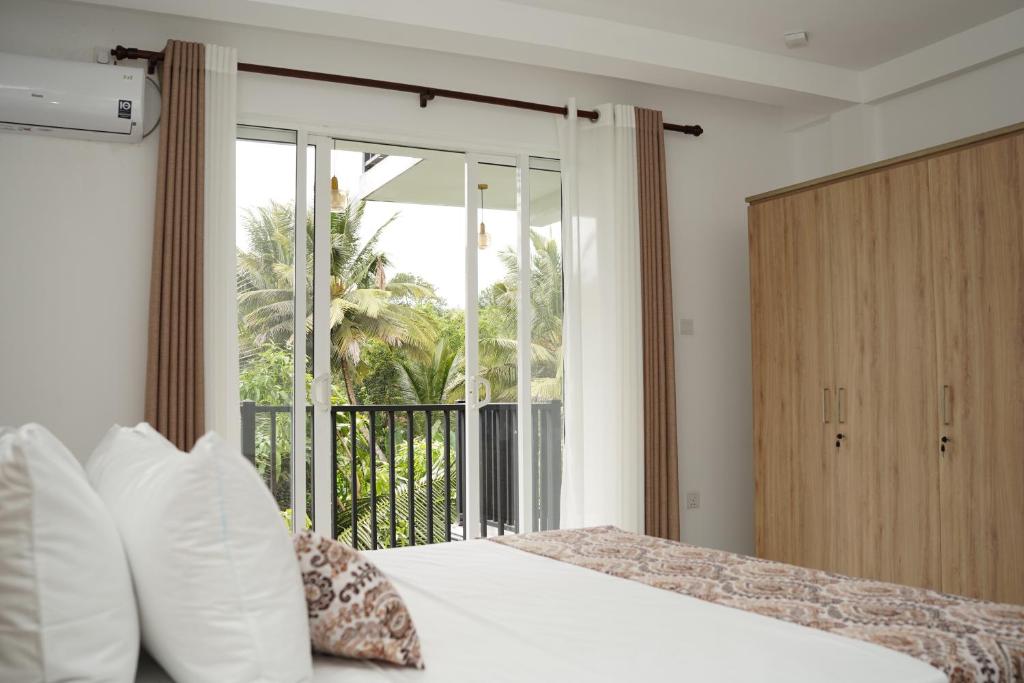 a bedroom with a bed and a large window at Meadow Breeze in Kandy