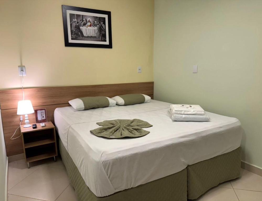 a bedroom with a bed with a hat on it at Domus Hotel Trindade - Canaã dos Carajás in Canaã dos Carajás