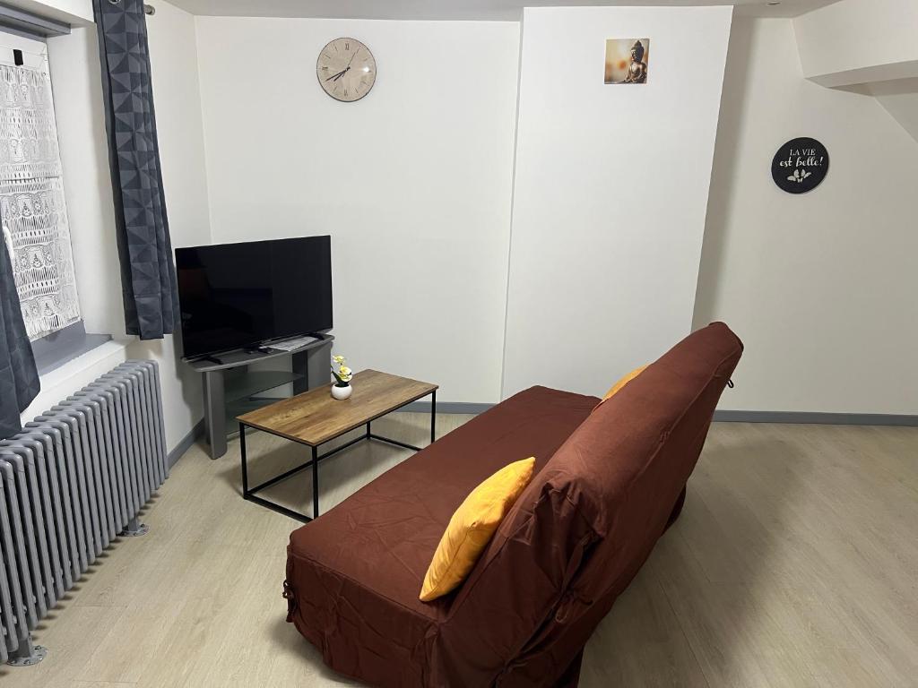 a living room with a brown couch and a table at Appartement asskaf spacieux T2 in Cambrai