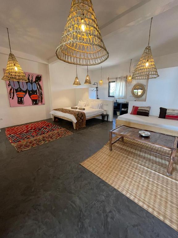 a large room with two beds and two tables at Kalao beach in Cap Skirring