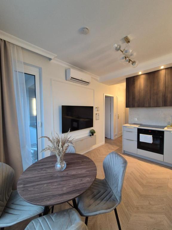 a kitchen and dining room with a table and chairs at STARCO Apartamenty obok dworca in Stargard