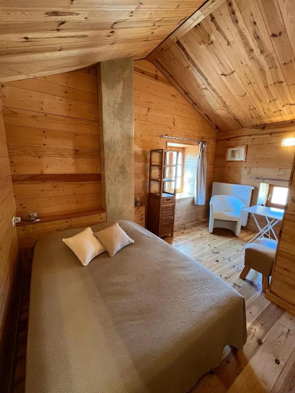a bedroom with a large bed in a wooden room at Chambre de charme in Berbezit