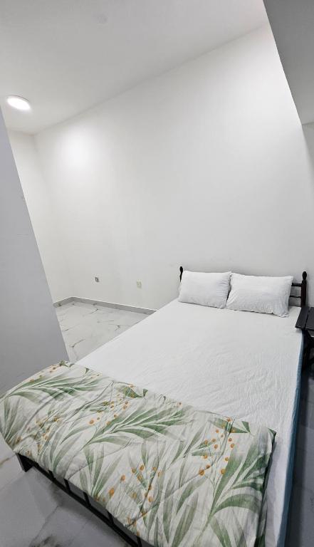 a bed in a room with a white wall at Everest Stay in Abu Dhabi