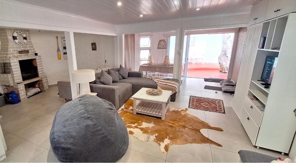 a living room with a couch and a table at Die Boomhuis. Pearly Beach in Pearly Beach