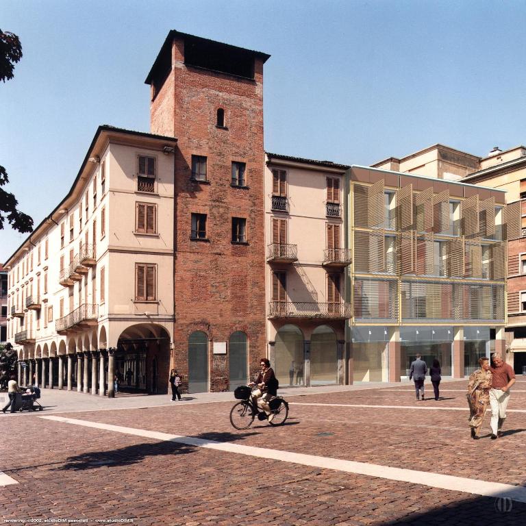 a person riding a bike in front of a building at Appartamenti Torre del Capitano in Cremona