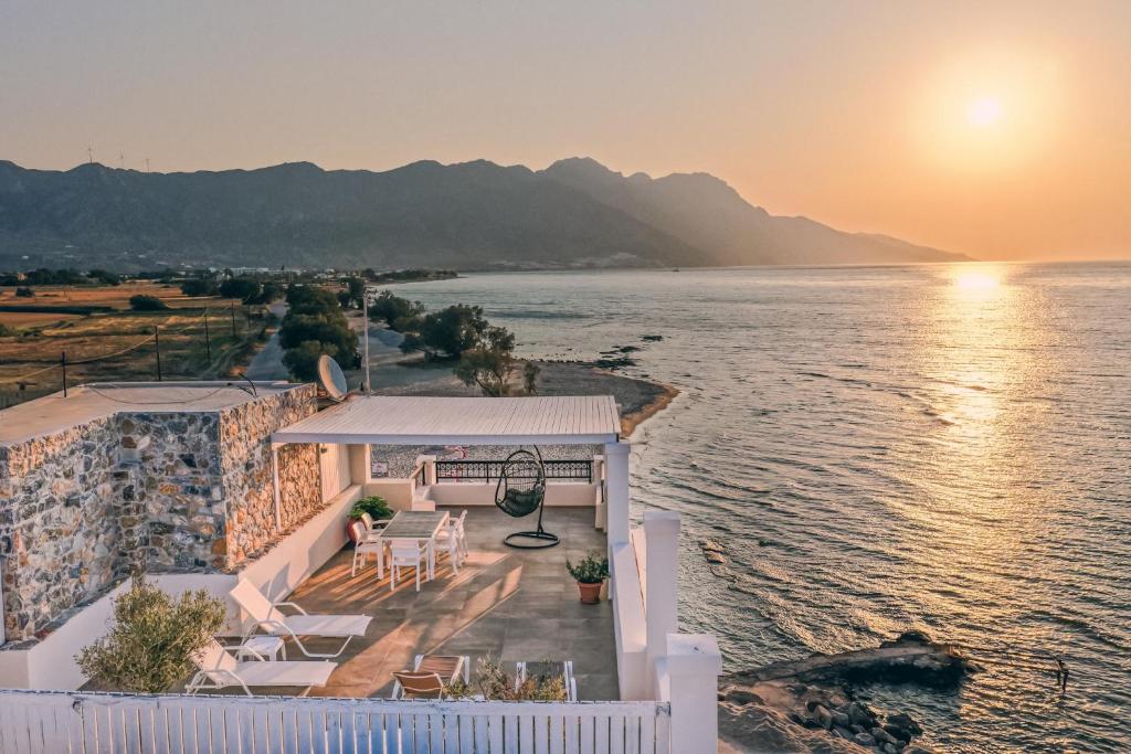 a house on the shore of the water with the sunset at Ostria View in Kardamaina
