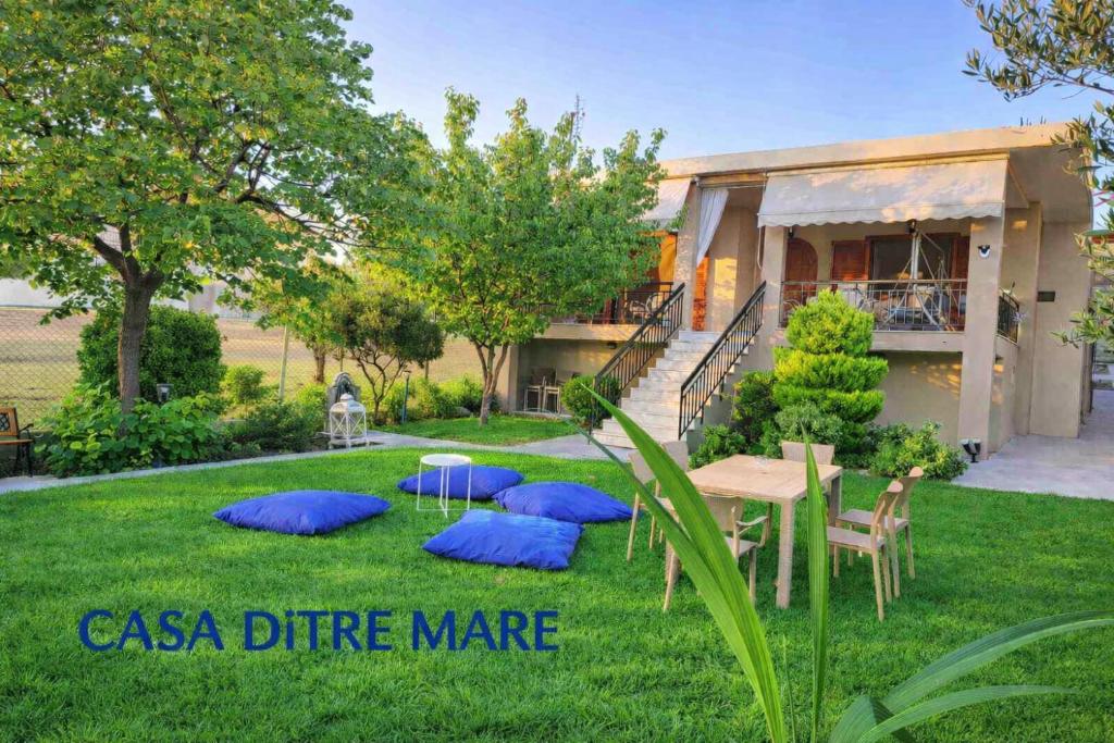 a yard with a table and chairs and a house at CASA Di TRE MARE in Nea Kallikrateia