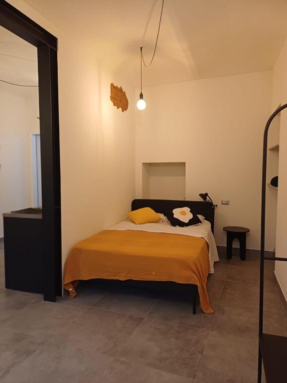 ein Schlafzimmer mit einem Bett mit einer orangefarbenen Decke in der Unterkunft casa cinna in Montà