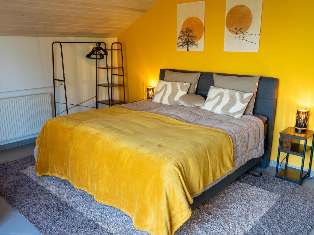 a bedroom with a large bed with a yellow wall at Landhaus Kummerfrei in Hellenthal