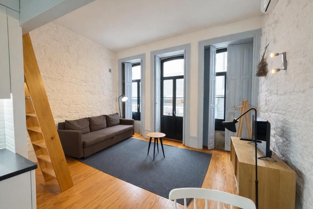 a living room with a couch and some windows at Oporto City View - Trindade in Porto