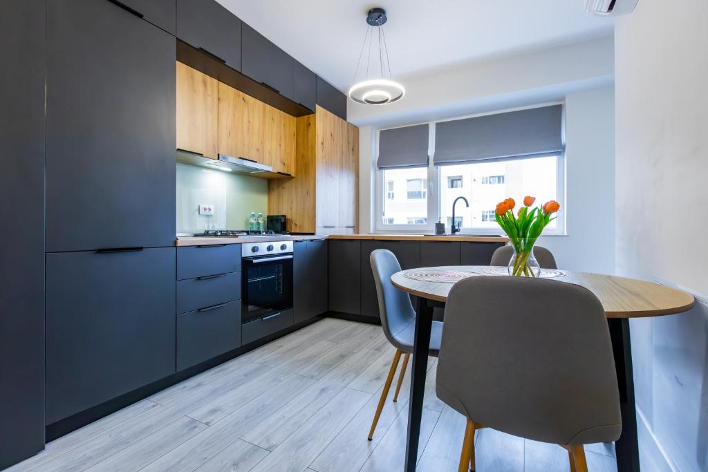 a kitchen with a table and chairs and a kitchen with cabinets at Rezidential Bacovia Orange by Rooms in Bacău