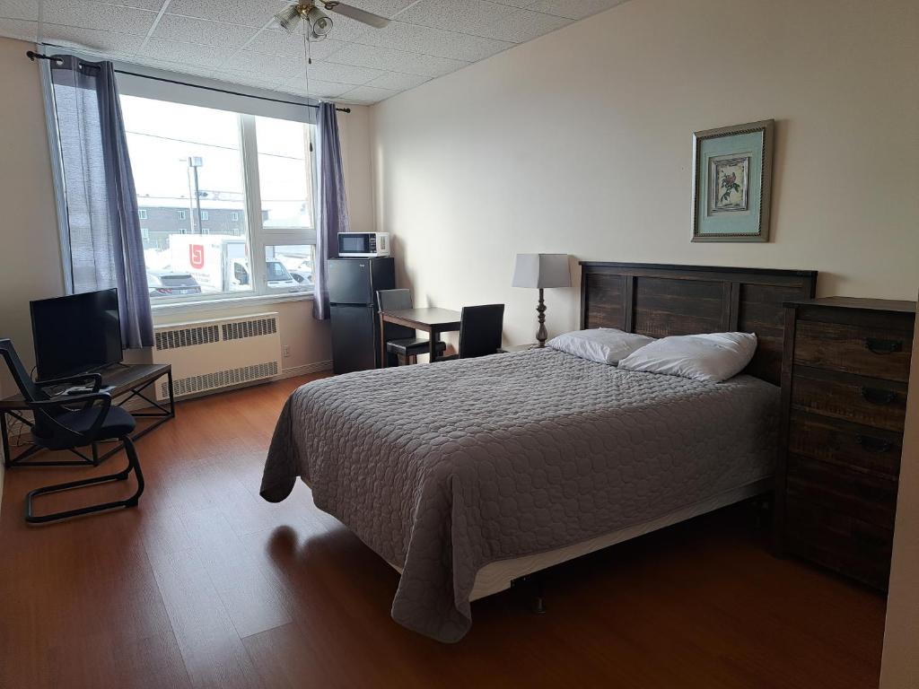 una camera da letto con un letto, una scrivania e una finestra di Quartier Nomade ad Amos