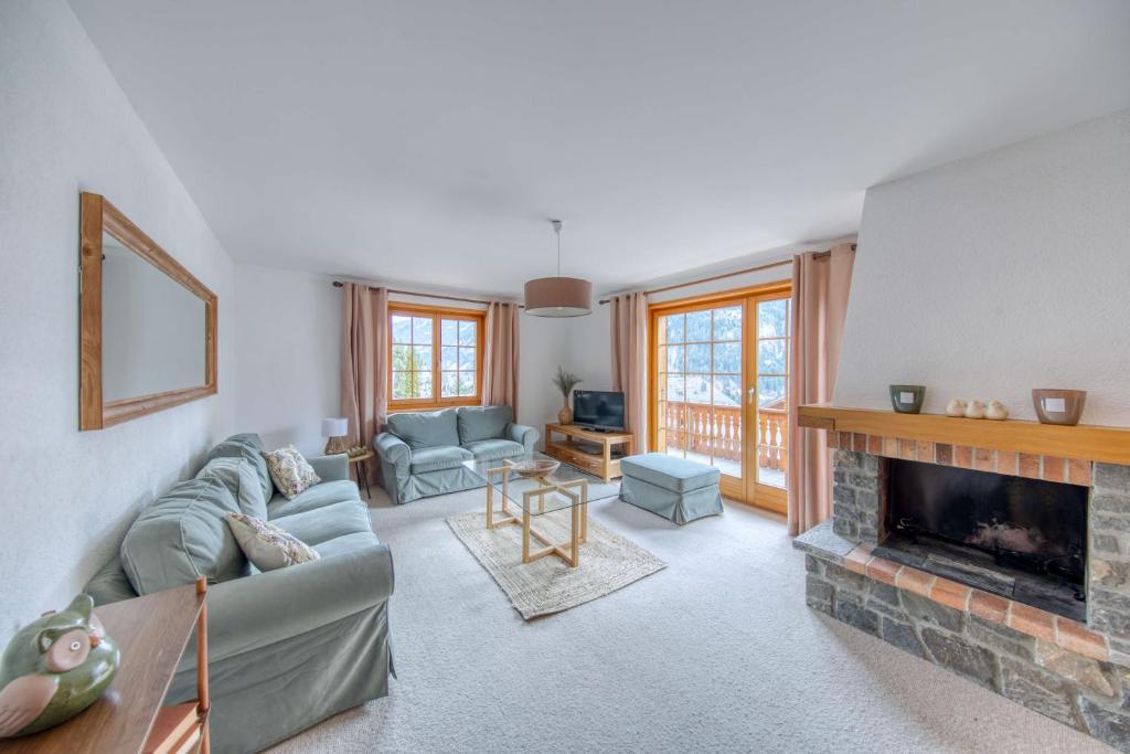 a living room with a couch and a fireplace at Centrally located with great views and terrace in Champéry
