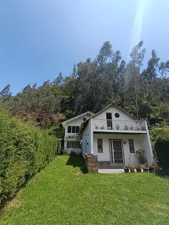 a white house with a balcony on a yard at Villablanca in Cuenca