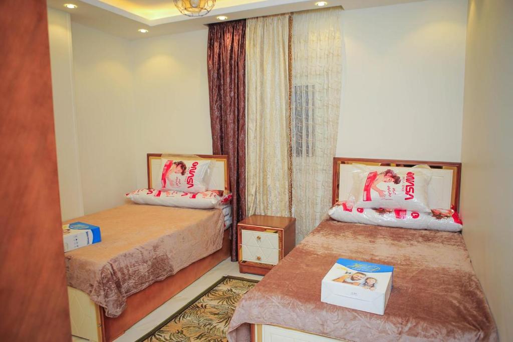 a small room with two beds and a window at الزقازيق in Kafr Muḩammad Ḩusayn