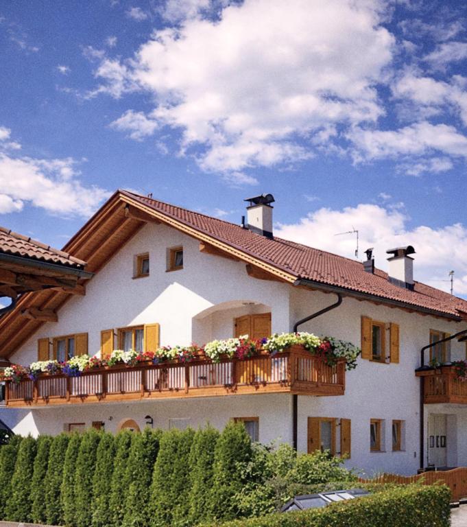 a house with a balcony with flowers on it at Landhaus Anita Dolomiten Kronplatz in Perca