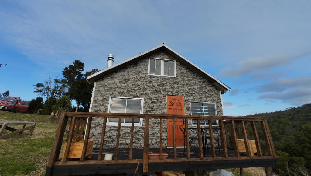 a house on a wooden deck with a house at Cabaña con tinaja Aucaco in Ancud